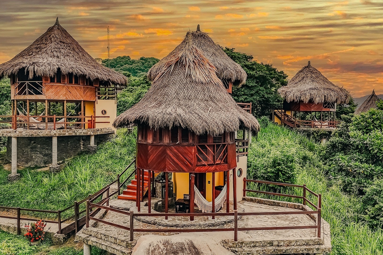 Ecohabs Tequendama: Rustic huts with thatched roofs nestled in lush green surroundings near Tayrona Park.