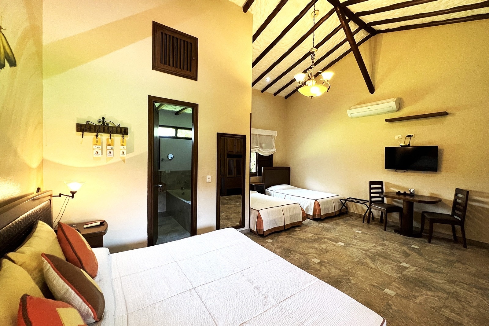 Tequendama Hotel Campestre Villavicencio: Bright room with two beds, TV, and patio access.