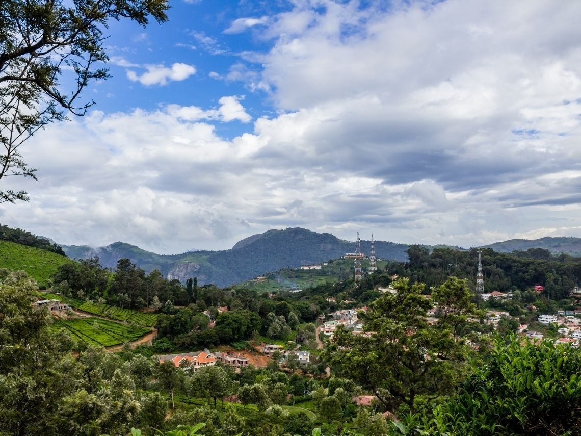 Scenic hotel view: lush tea plantations, mountains, and a town below. Book Hotels in Cali | Tequendama Hotels | Official Web.