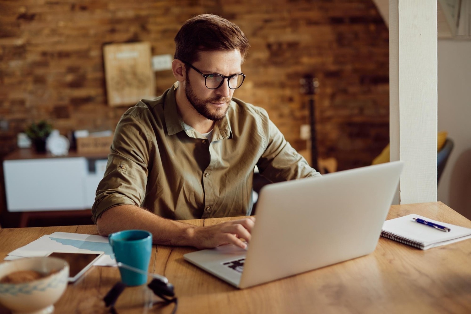 Modern Tequendama office: Man focused on laptop for corporate work.