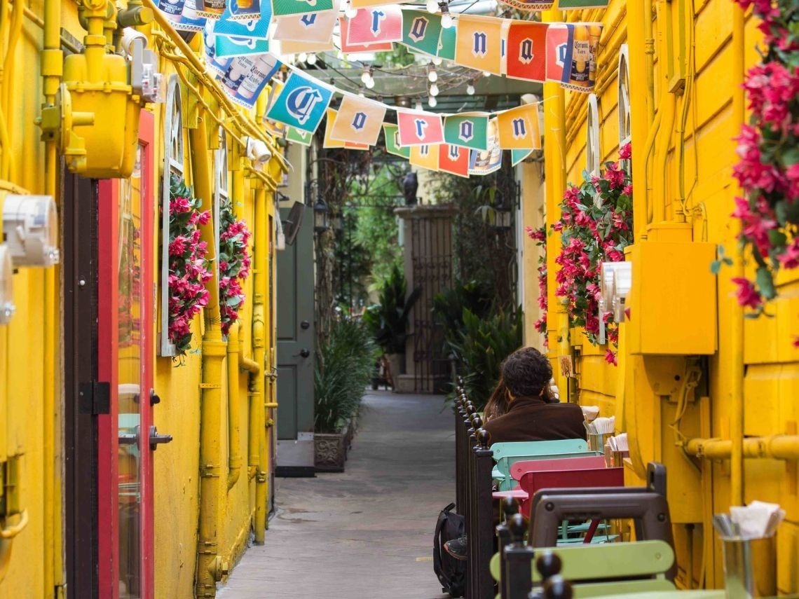 Atractivo callejón con luces y flores, mesas al aire libre. ¡Reserva tu estancia en Hoteles en Cartagena | Tequendama Hoteles | Web Oficial!
