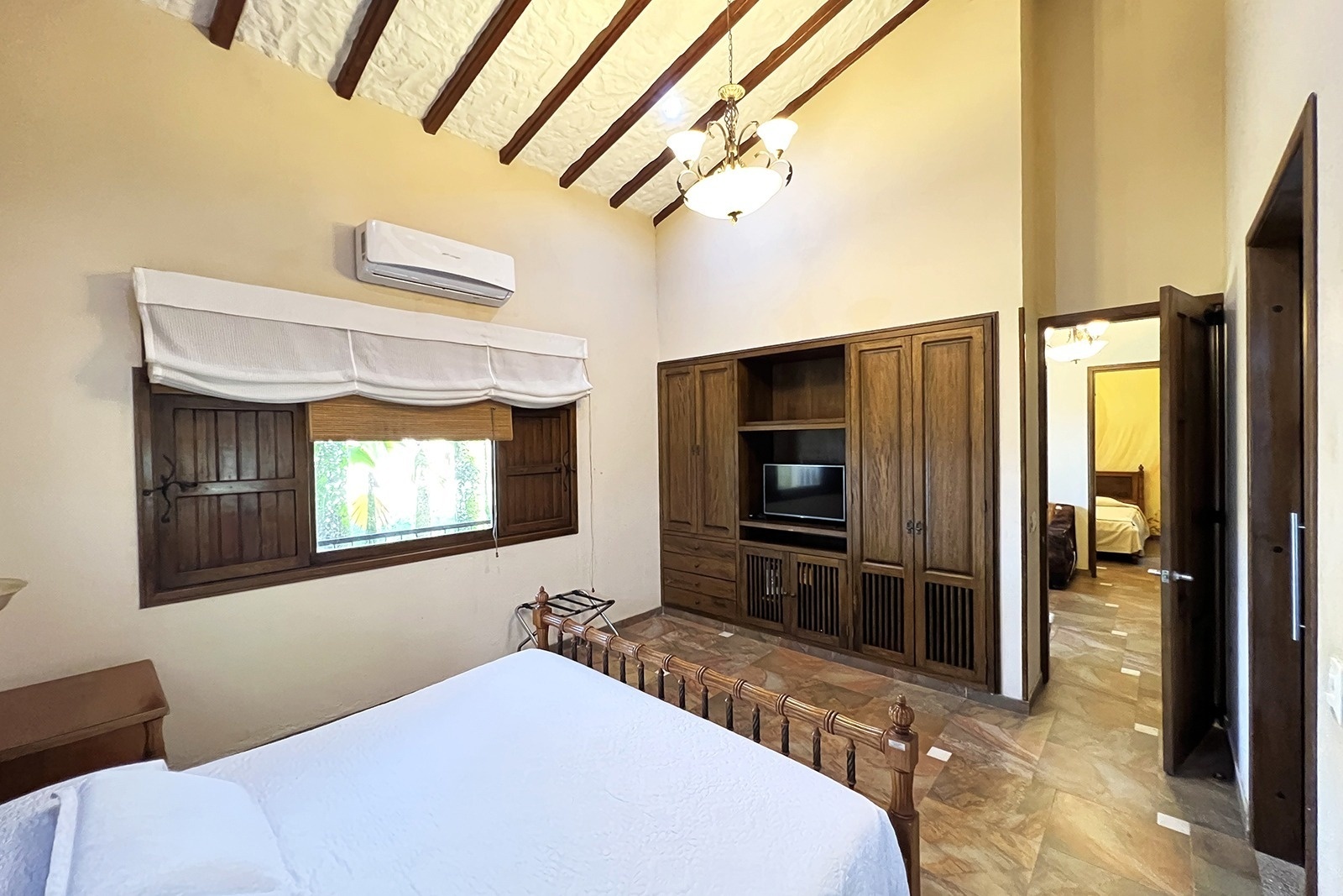 Cozy bedroom with wooden furniture and TV. Tequendama Hotel Campestre Villavicencio | Nature & Relaxation.