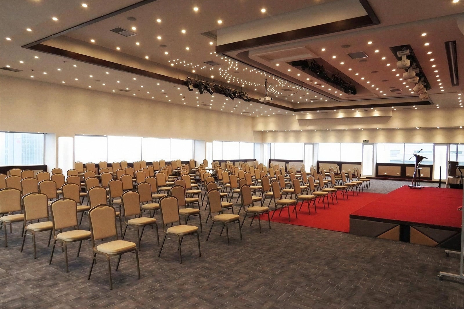 Spacious event hall with chairs and stage for Tequendama Suites Bogotá Events | Tequendama Hotels.
