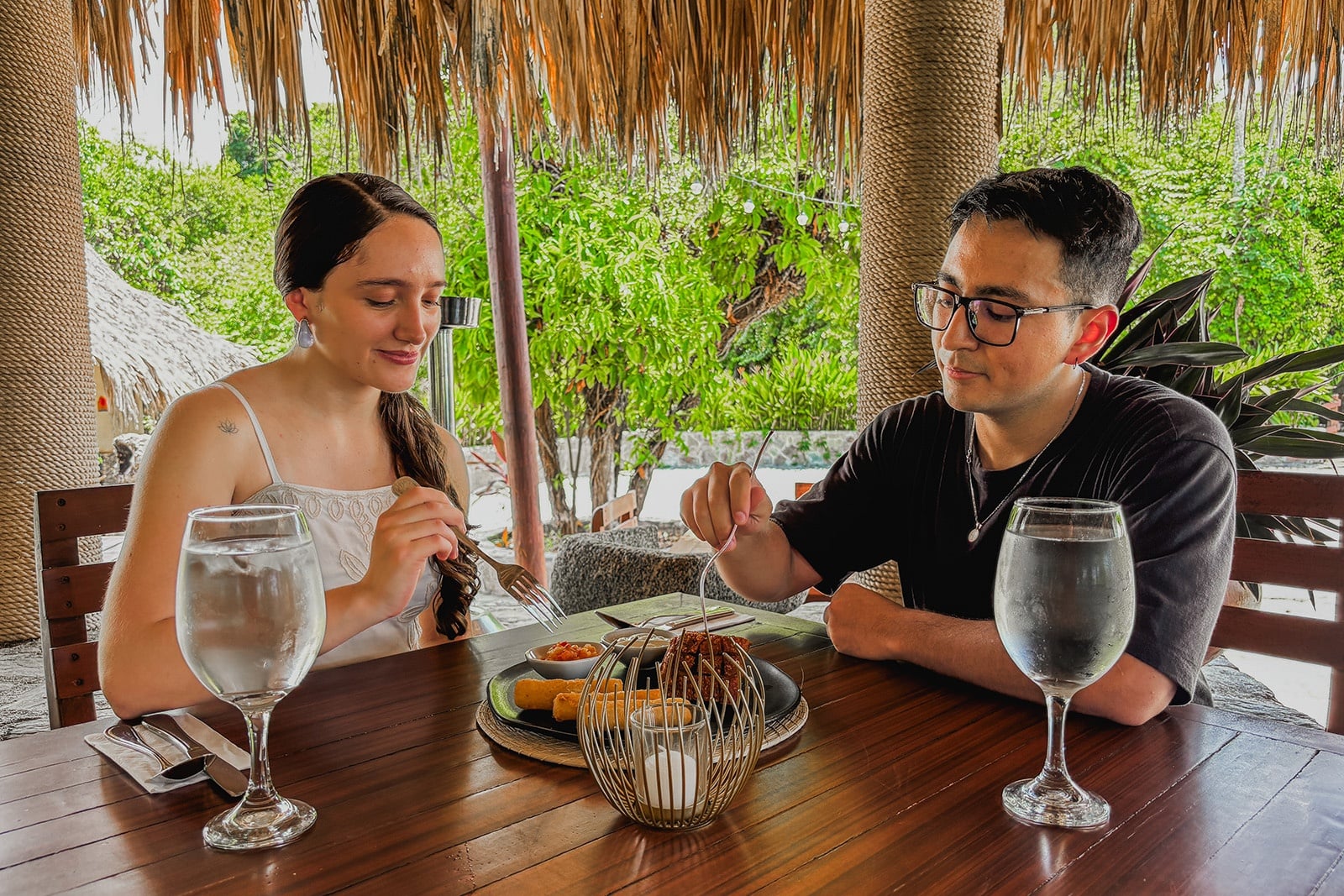 Pareja disfrutando cena romántica en Tequendama: Corporativa con vista a la naturaleza.