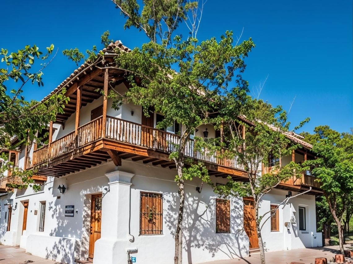 Edificio colonial blanco con balcón de madera en Tequendama: Corporativa.