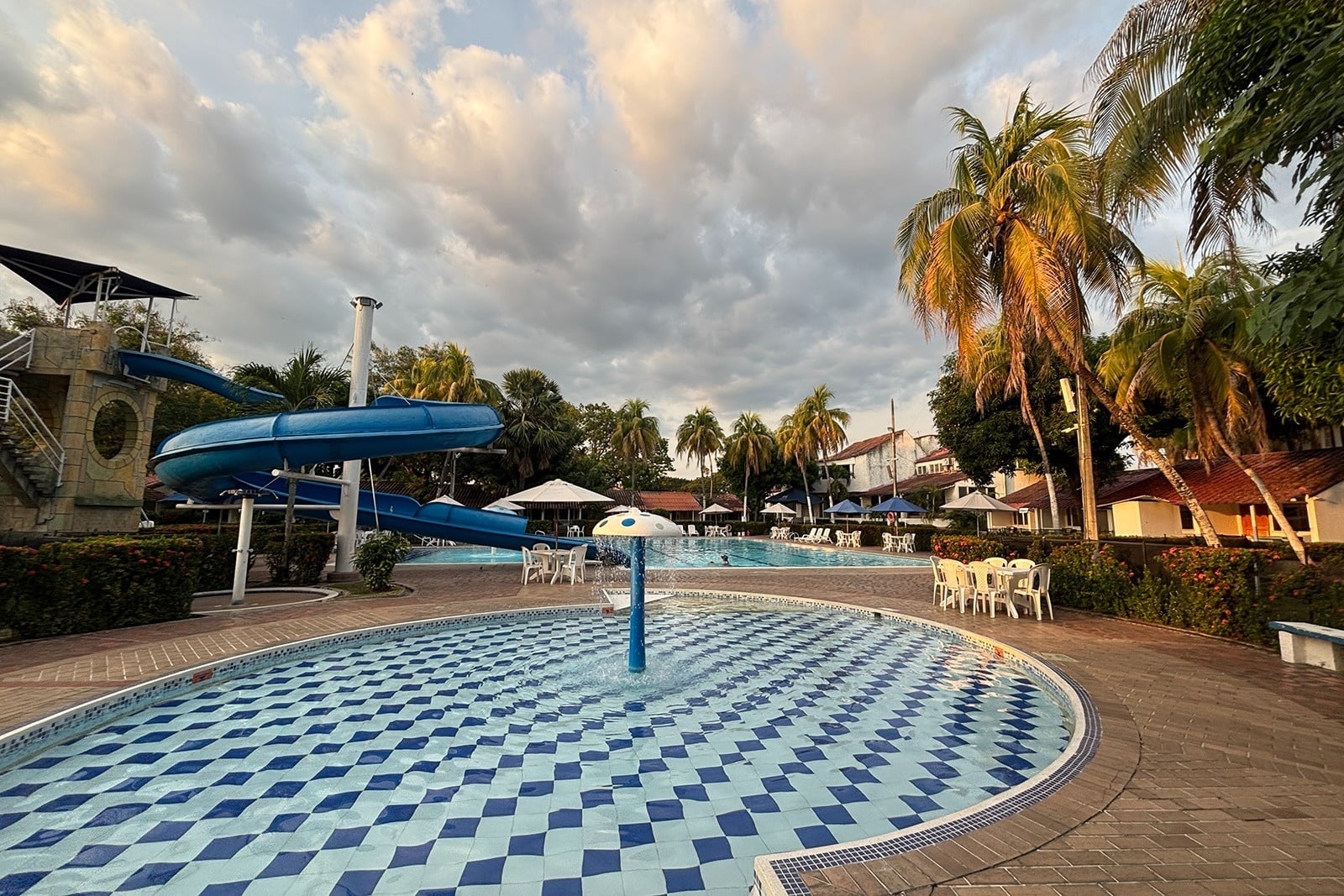 Piscina infantil con tobogán y palmeras en Tequendama: Corporativa