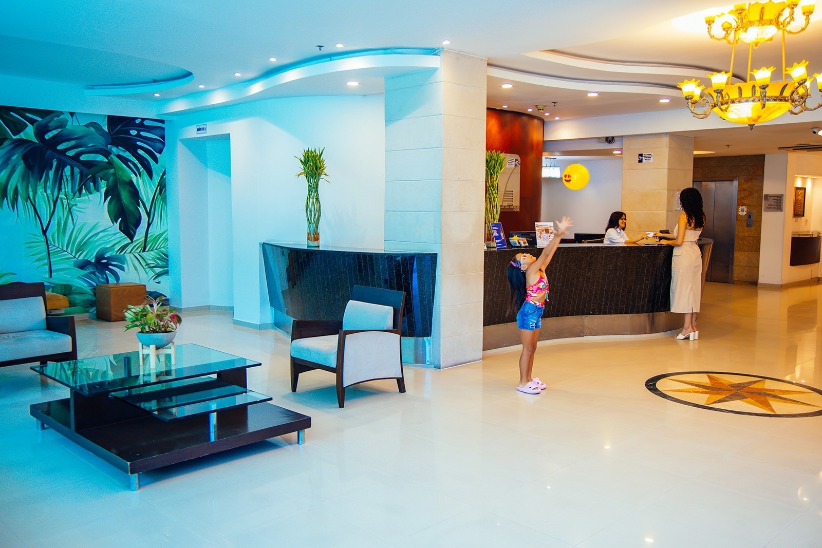 Hotel Plaza Las Américas: Lobby with reception, lounge area, and playful child. Book your stay!
