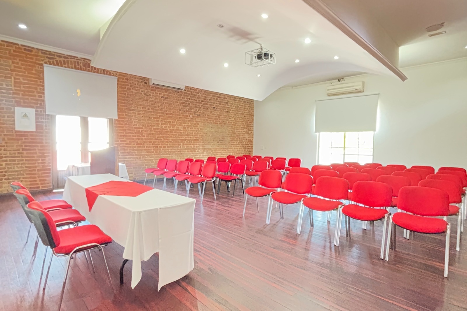 Salón de eventos con sillas rojas y mesa en Hotel Los Puentes Comfacundi.