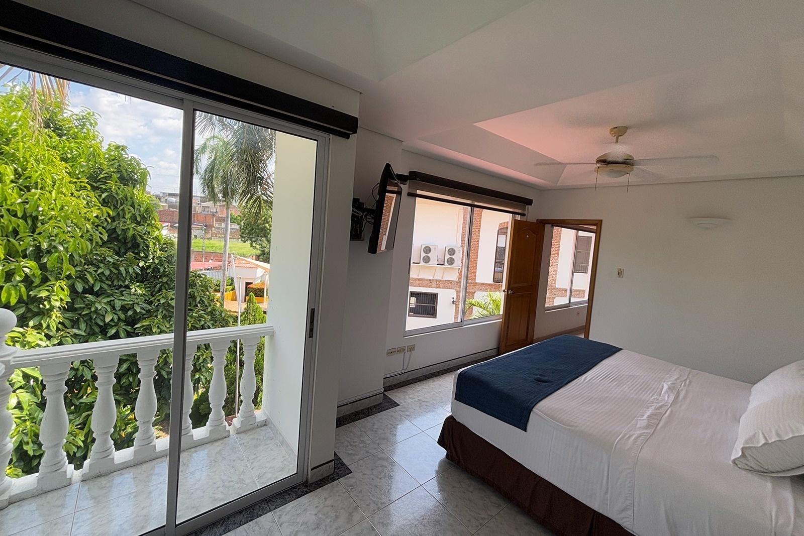 Hotel Los Puentes Comfacundi: Bright room with balcony overlooking lush greenery.