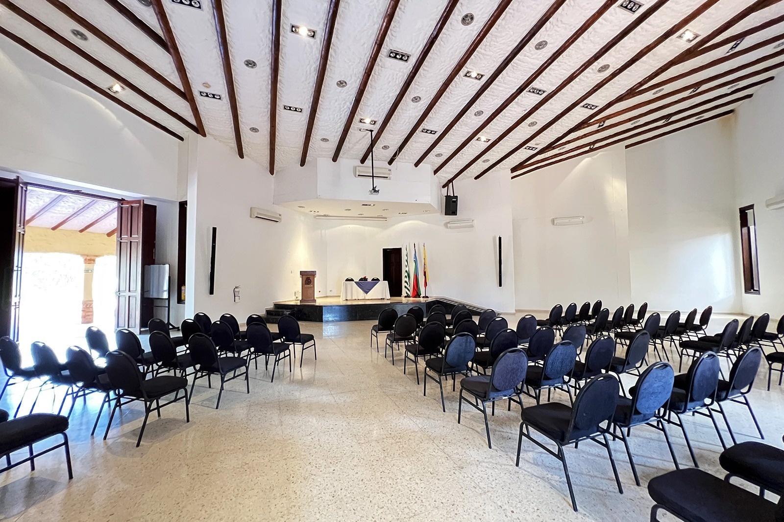 Salón para Eventos | Tequendama Hotel Campestre Villavicencio: sillas negras, tarima y escenario.