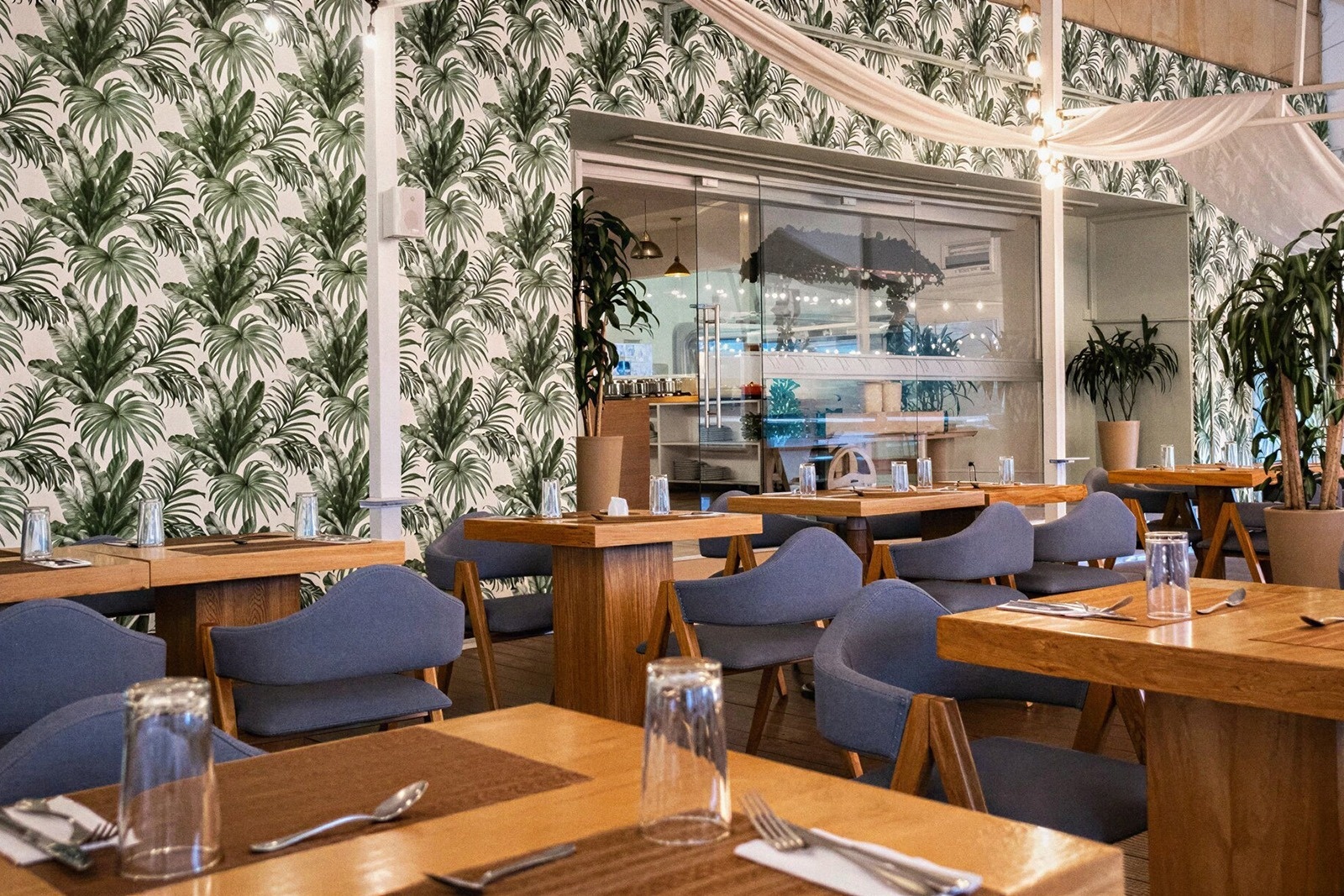 Tequendama Suites Bogotá: Chic restaurant with tropical wallpaper & seating.