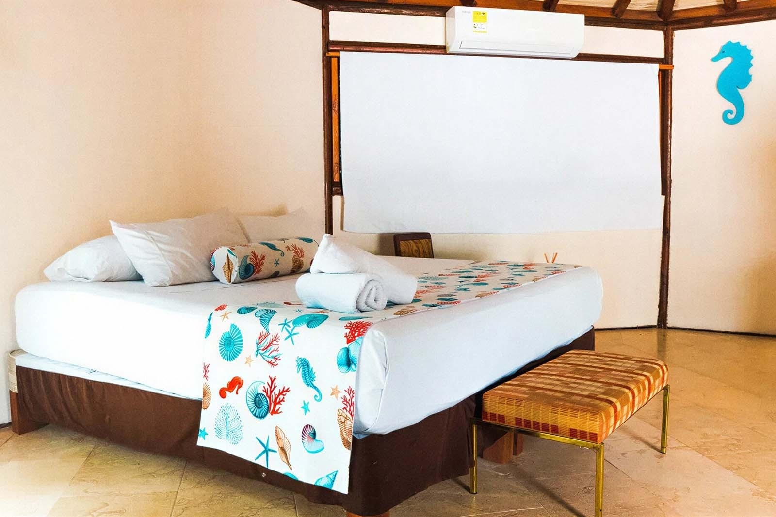 Hotel Rosario de Mar: Beach-themed bedroom with marine decor, king bed, and air conditioning.