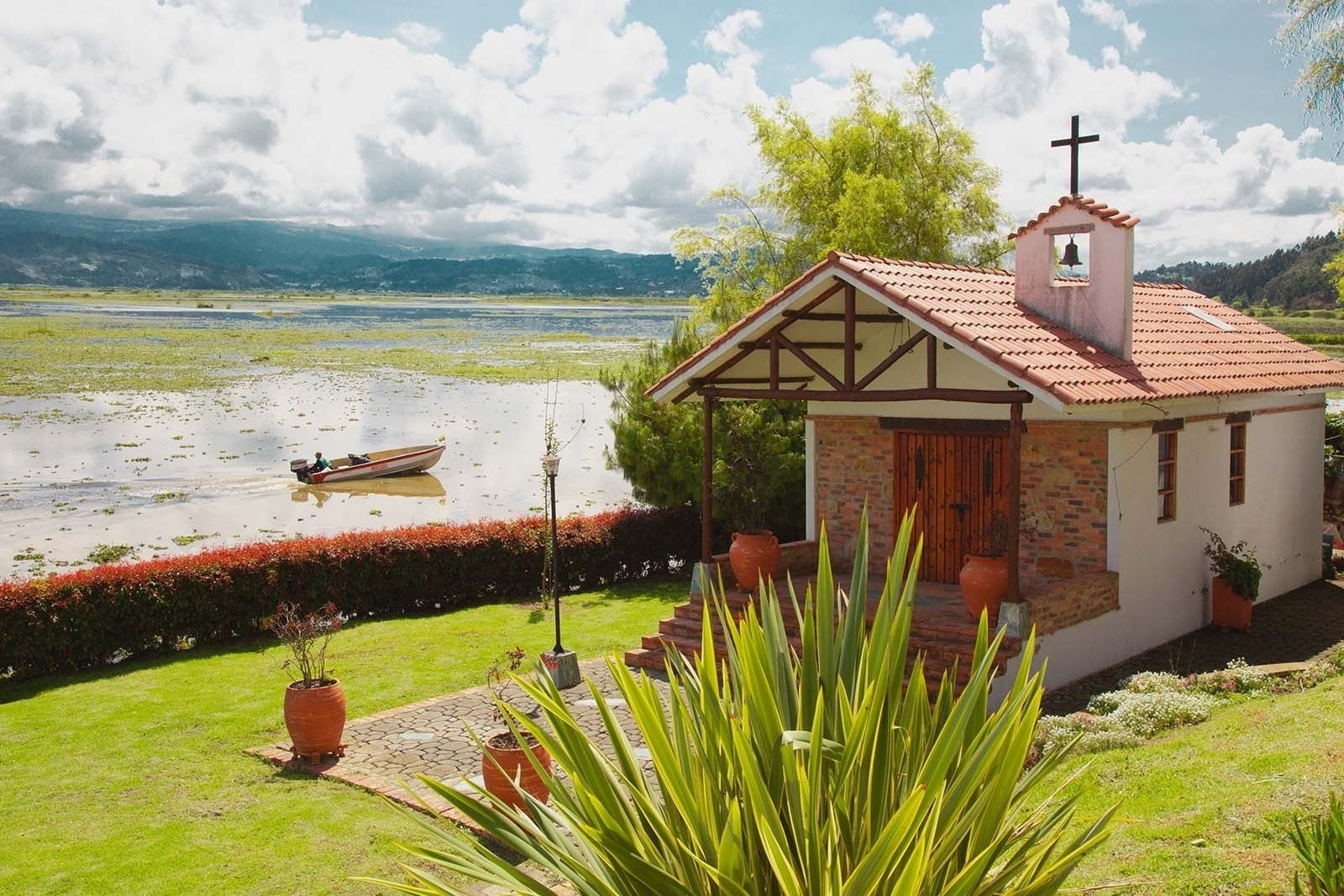 Hotel Refugio El Santuario: capilla junto a la laguna, vistas a la montaña y embarcación.