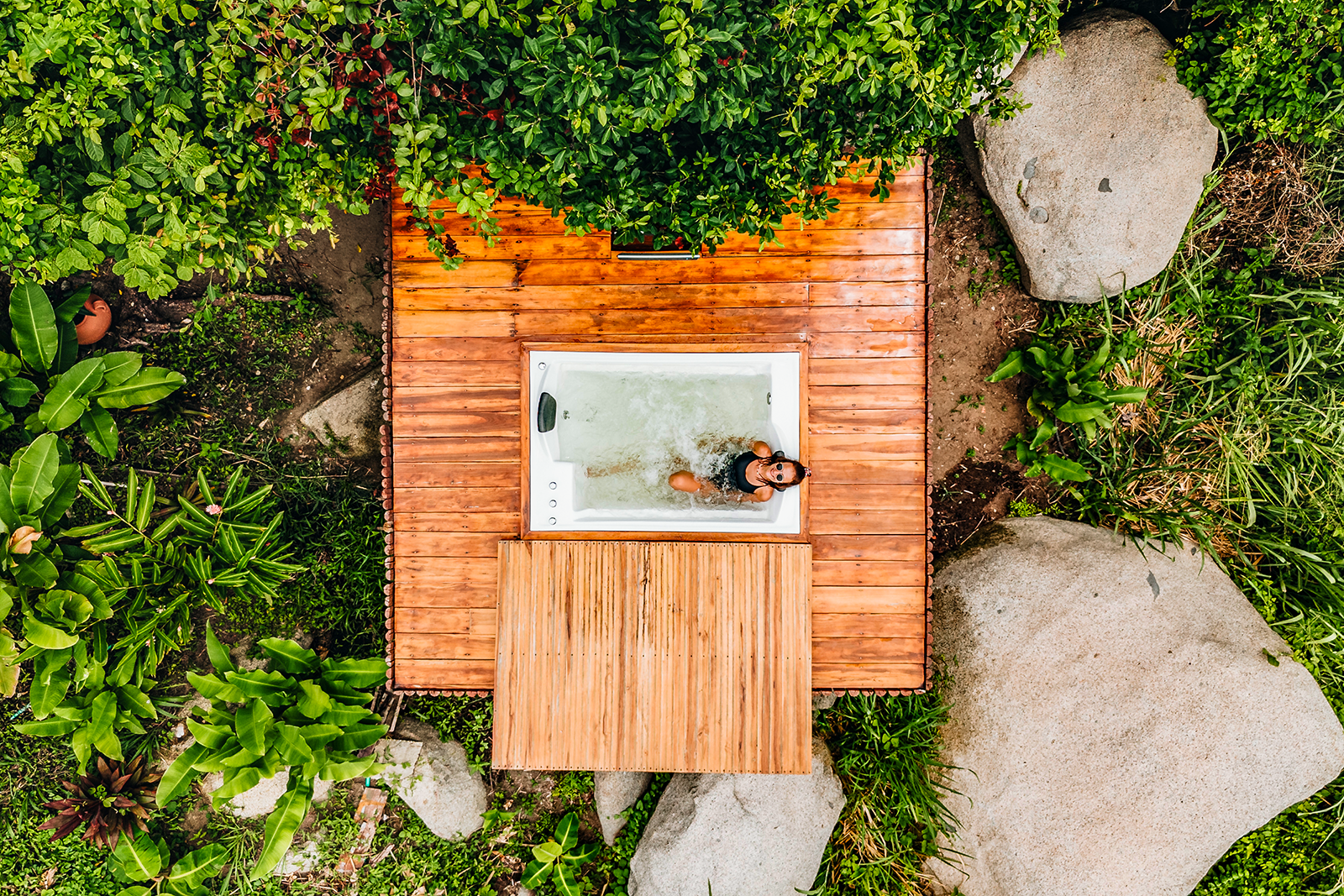 Tequendama: Corporativa - Woman relaxing in outdoor jacuzzi surrounded by nature.