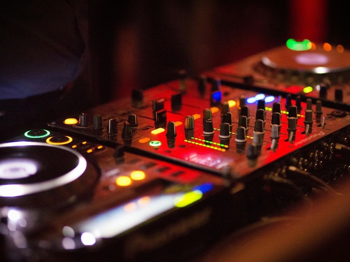Mezcladora DJ profesional Tequendama: Corporativa, luces rojas, perillas y tocadiscos.