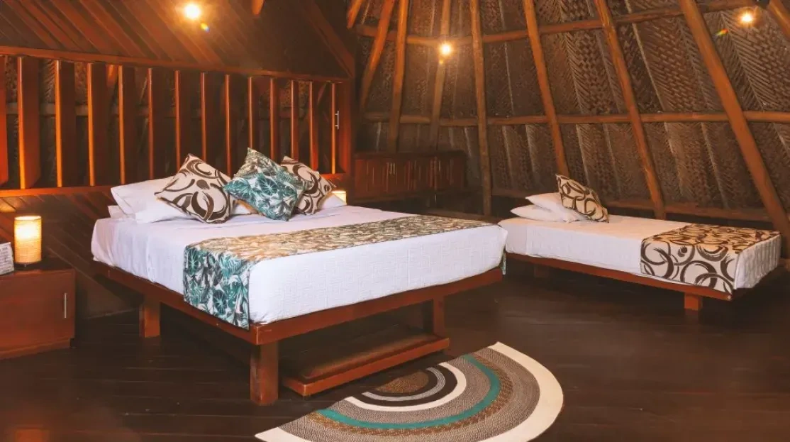 Habitación en Cabañas Tequendama | Hotel en Parque Tayrona, con dos camas y decoraciones naturales.