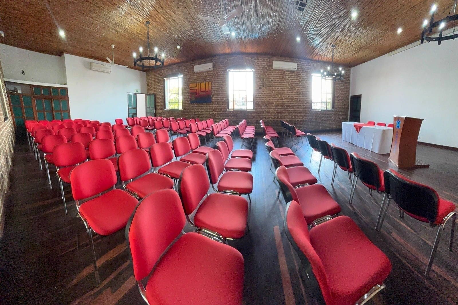 Salón Tequendama: Corporativa, sillas rojas, escenario para eventos corporativos.