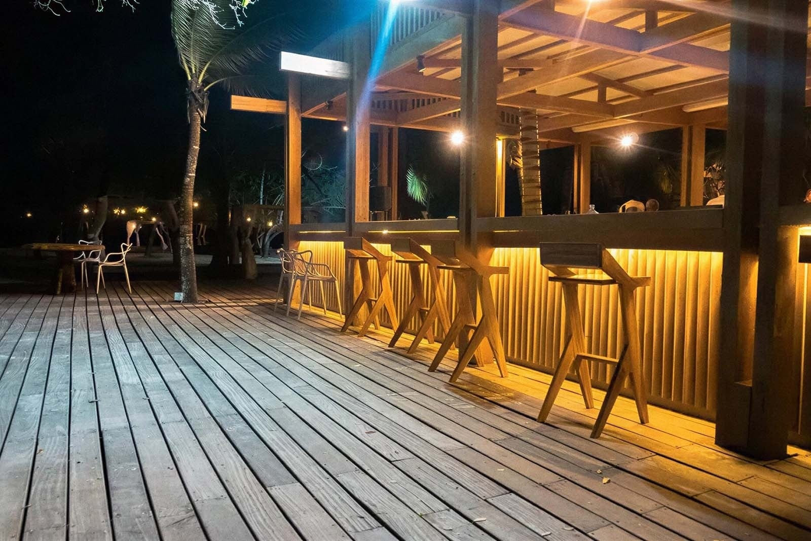 Bar al aire libre con taburetes, luces cálidas y mesas para la experiencia Tequendama: Corporativa.