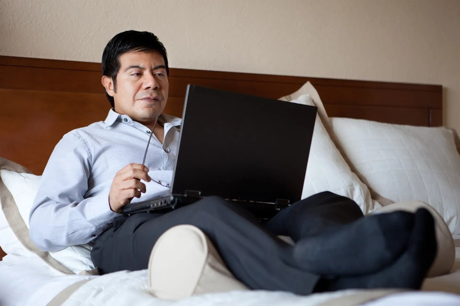 Hombre de negocios en Tequendama: Corporativa, usando laptop en la cama.