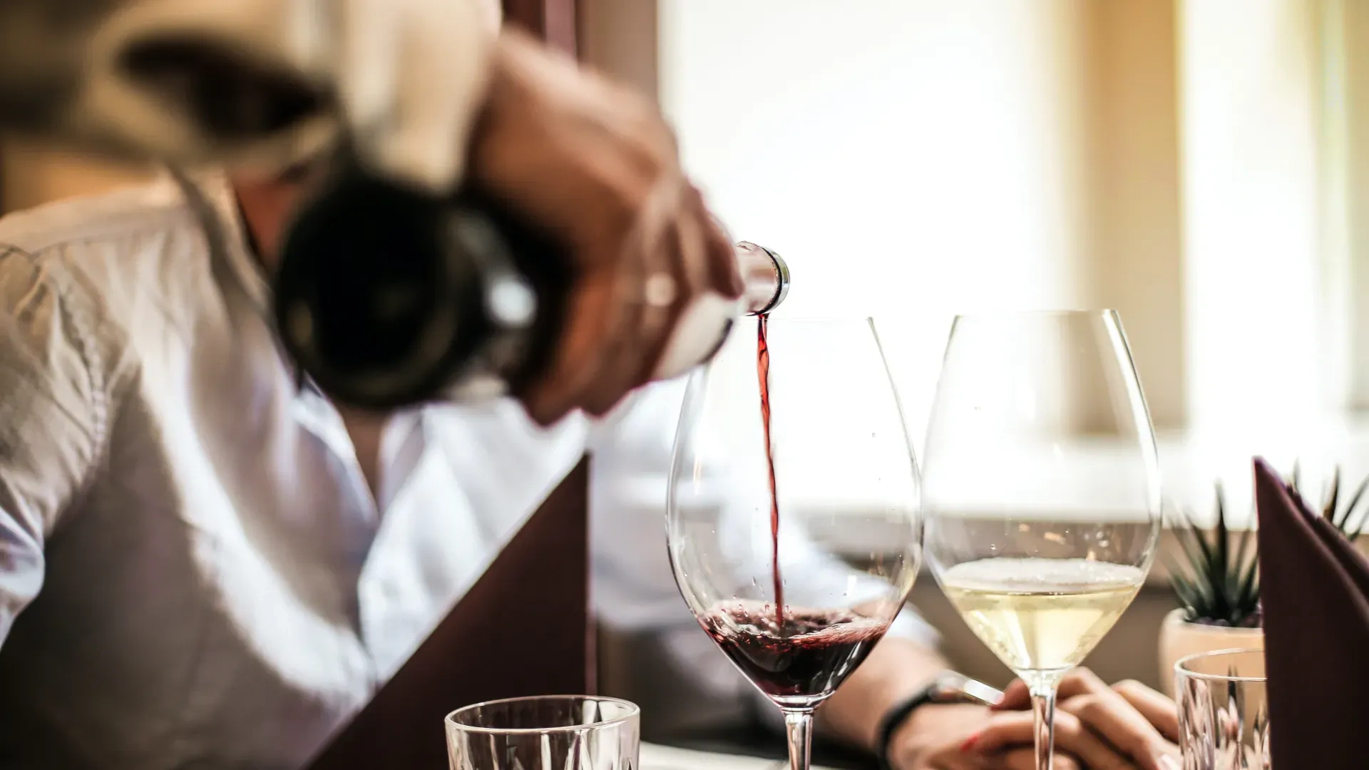 Work with Us | Tequendama Hotels | Colombia | Official Web: Pouring red wine at a formal dining table, ideal for hotel events.