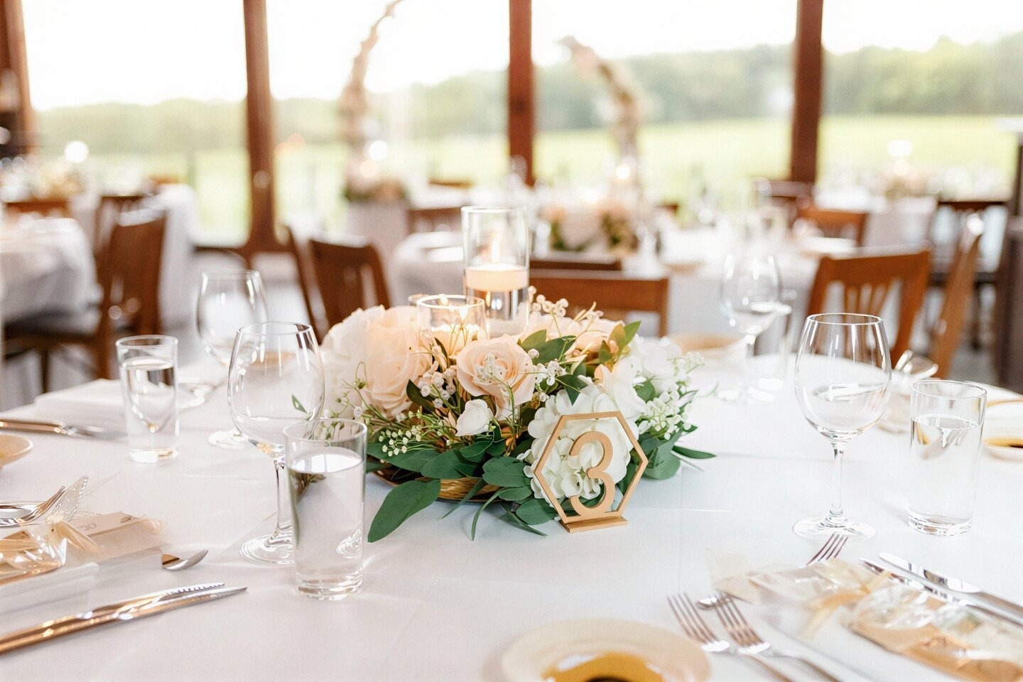 Mesa de banquete elegante con centro floral y número '3' en Tequendama: Corporativa.