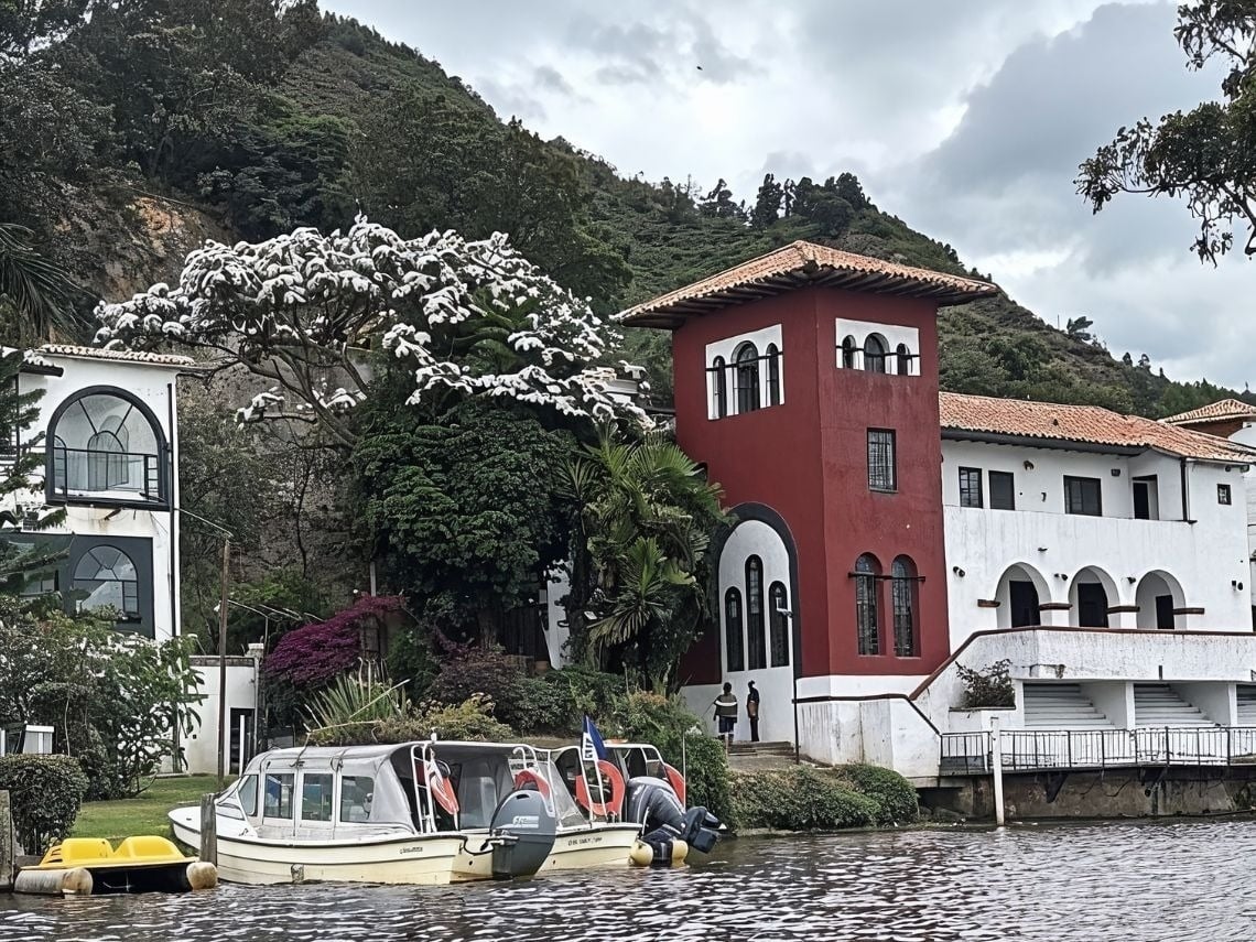 Edificio con torre roja y blanca frente al lago, Cundinamarca. Hoteles en Cundinamarca.