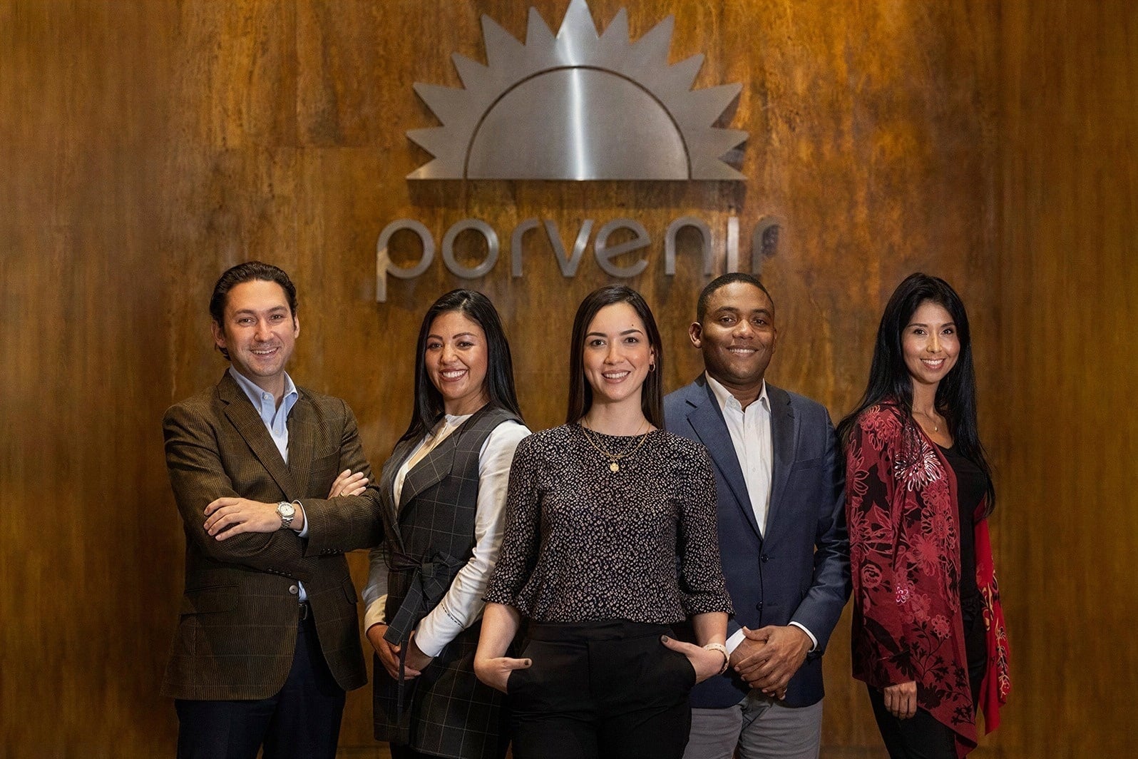Equipo de Tequendama: Corporativa sonriendo frente al logo.