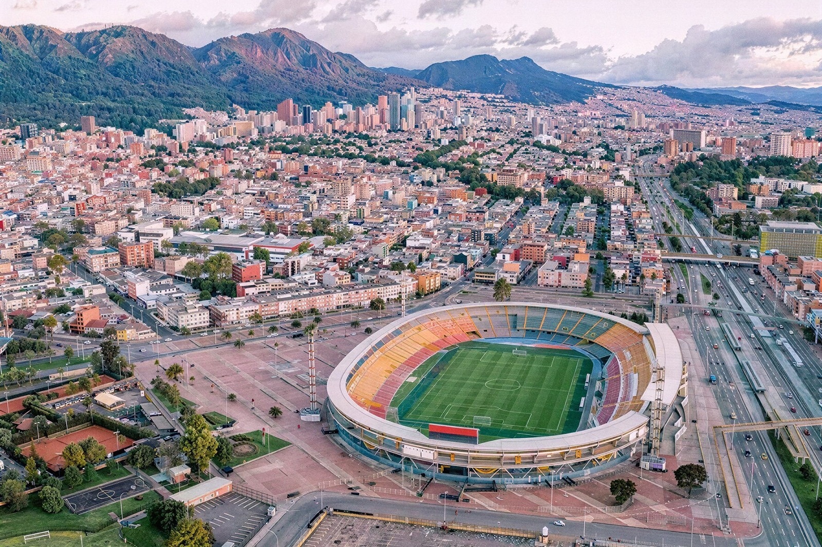 Vista aérea del Estadio Tequendama: Corporativa, rodeado de la ciudad y montañas.