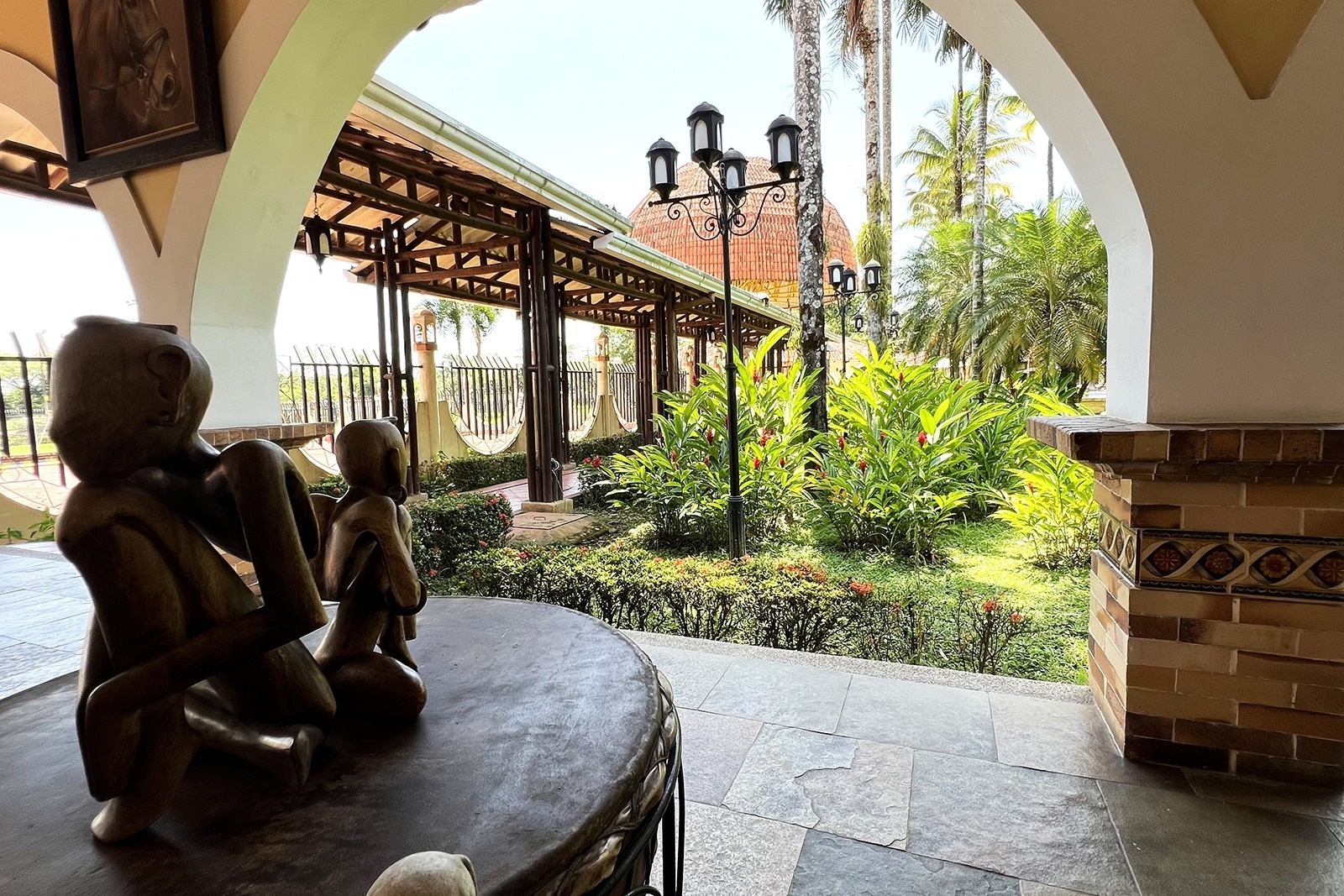 Tequendama Hotel Campestre Villavicencio: Outdoor seating area overlooking tropical gardens and architecture.
