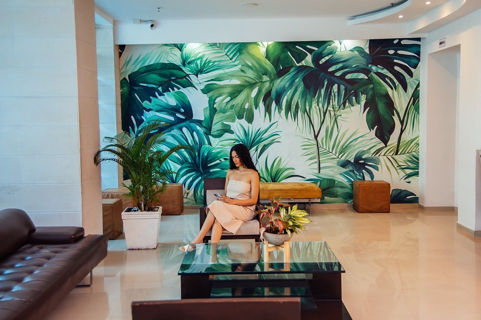 Hotel Plaza Las Américas: Woman on sofa, tropical mural. Book now!