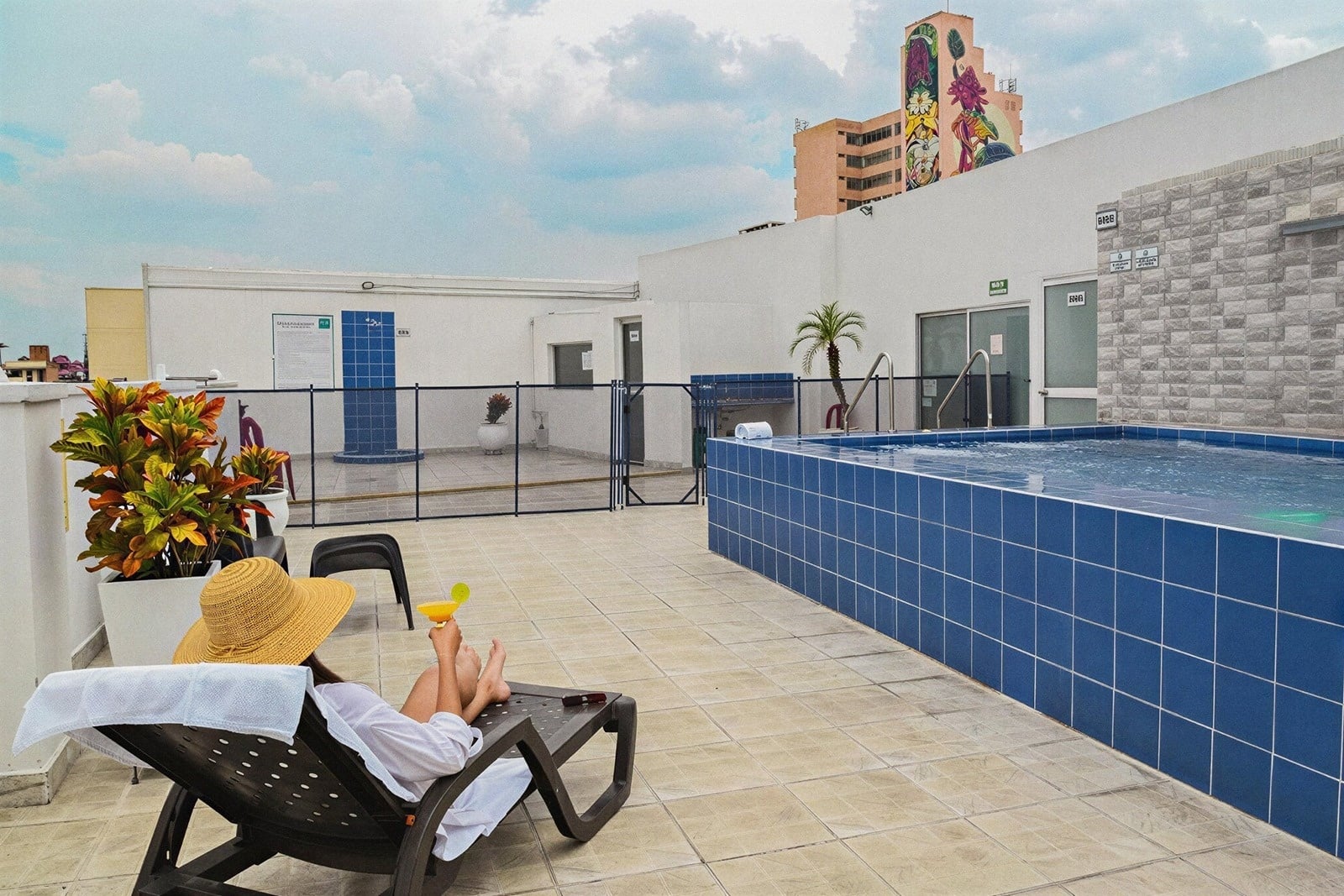 Tequendama: Corporativa. Rooftop pool with view and woman relaxing.