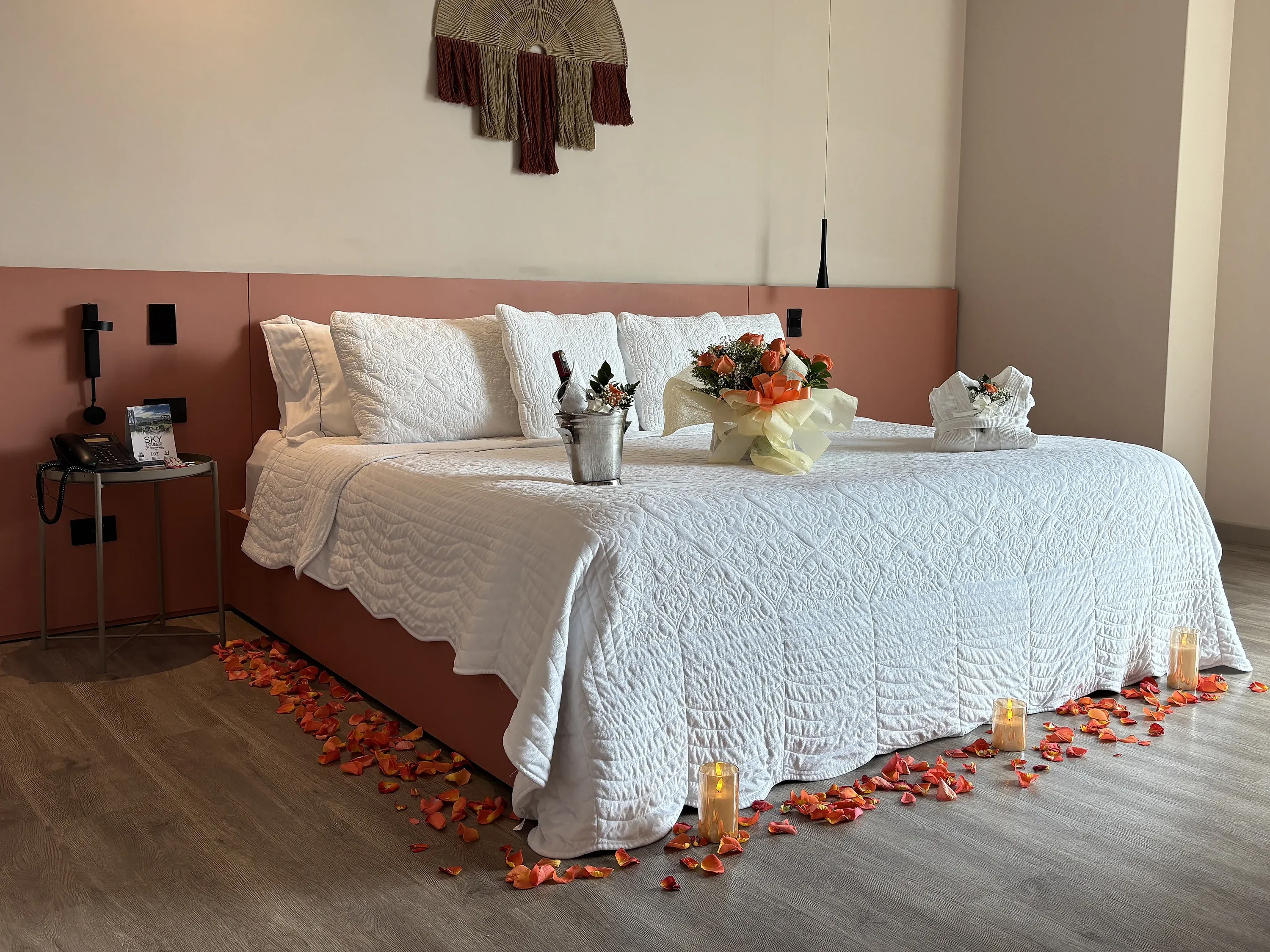 Cama romántica con pétalos de rosa, velas y flores, ideal para Tequendama: Corporativa.