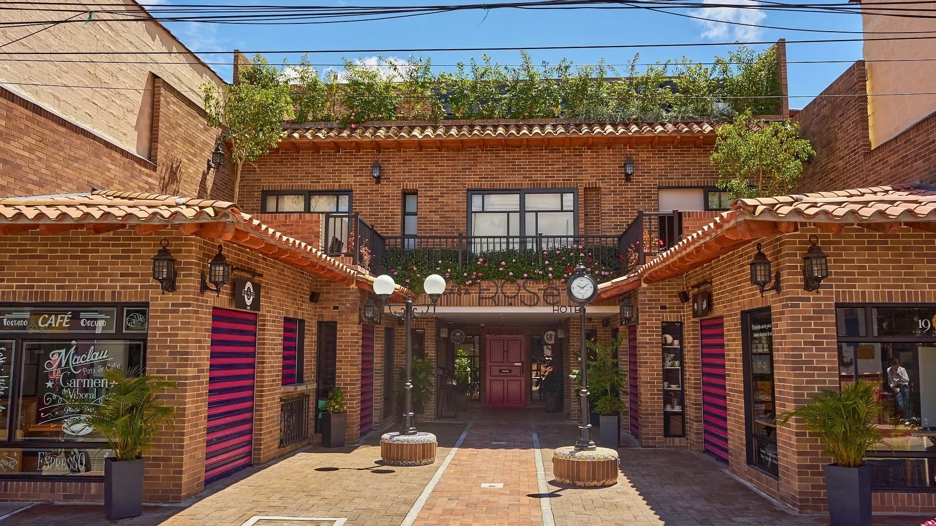 Casa Rosé Hotel: Charming boutique hotel entrance with brick facade and lush greenery.