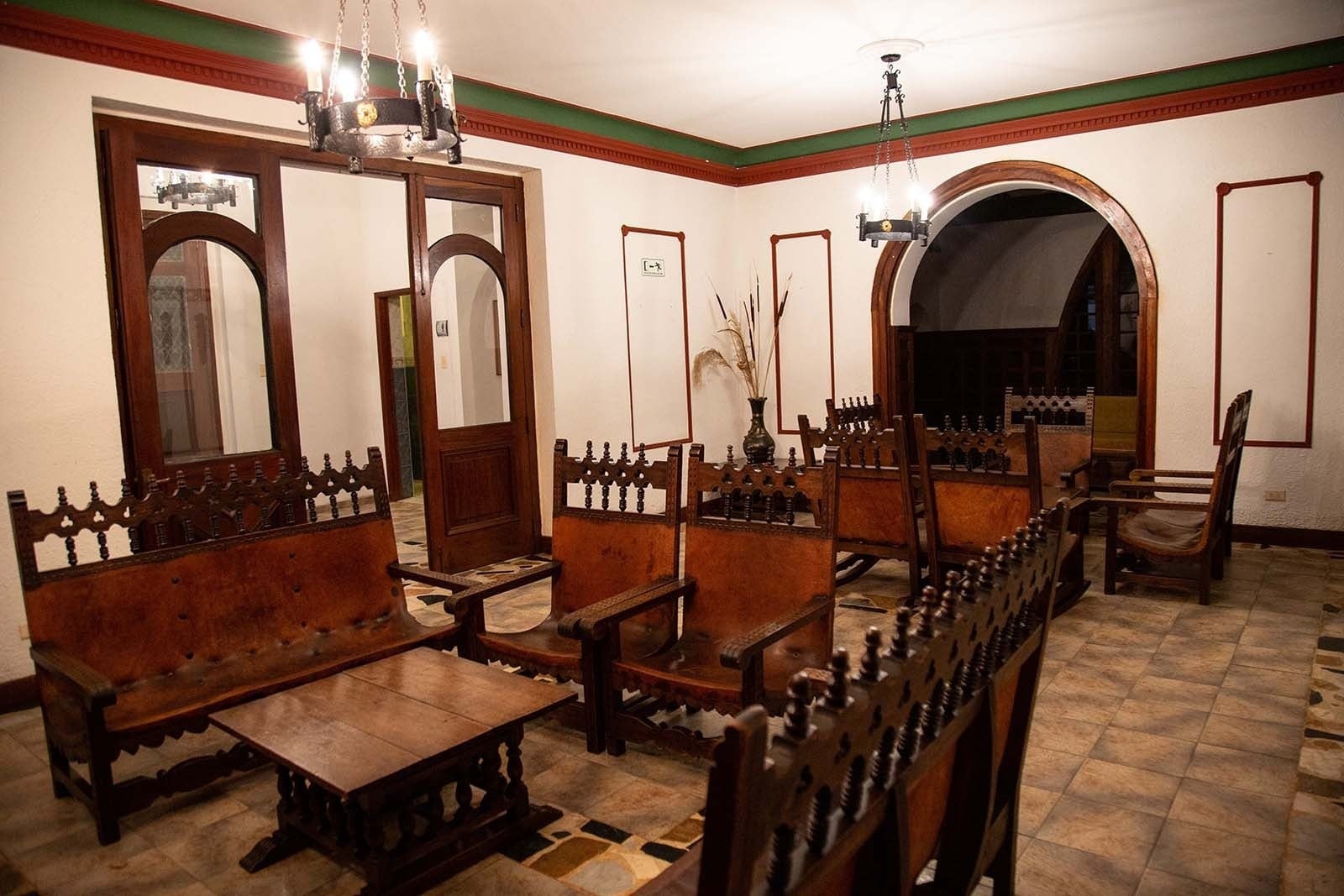 Sala de estar con muebles de madera y cuero en Hotel Refugio El Santuario, Laguna de Fúquene.