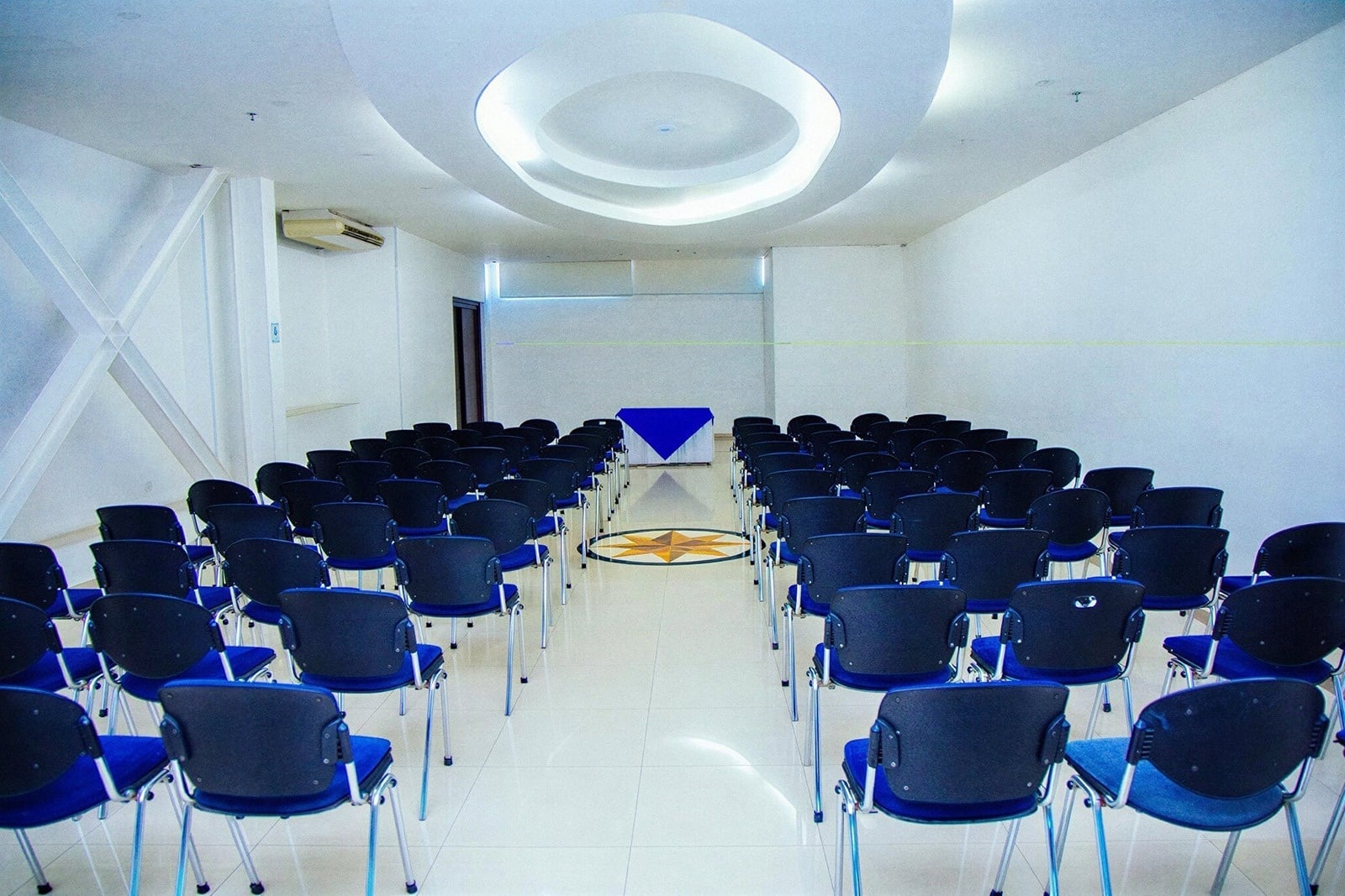 Sala Tequendama: Corporativa equipada con sillas azules y mesa central.