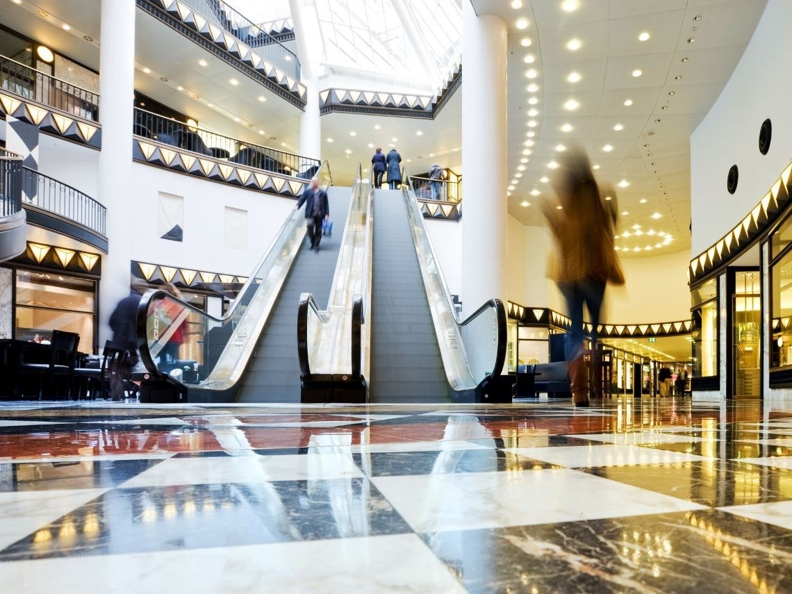 Interior moderno del Hotel Tequendama: Corporativa con escaleras mecánicas y elegante suelo de mármol.