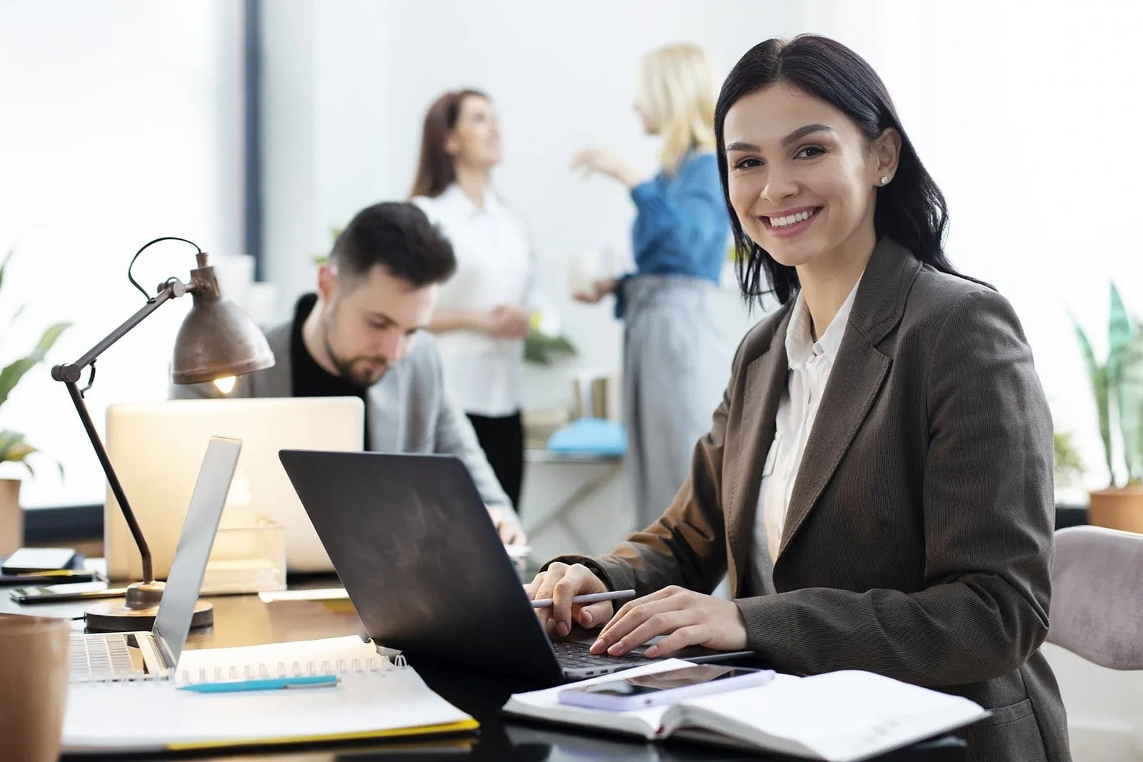 Tequendama: Corporativa, sonriendo mientras trabaja en su laptop