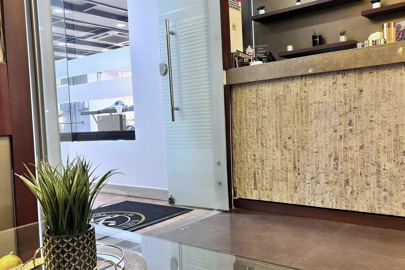 Welcome to Tequendama Suites Bogotá, a modern reception area with a plant and a textured wall.