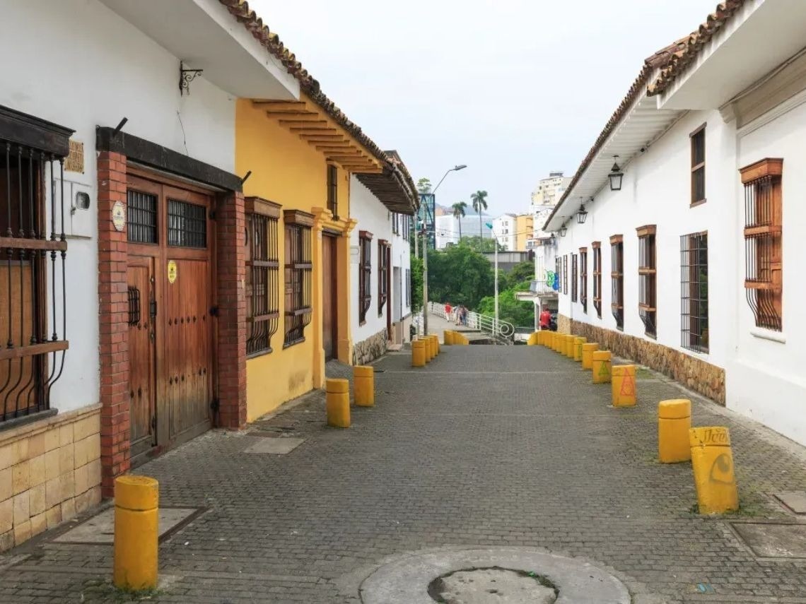 Charming street with yellow bollards leading to Hotels in Cali. Book your stay!