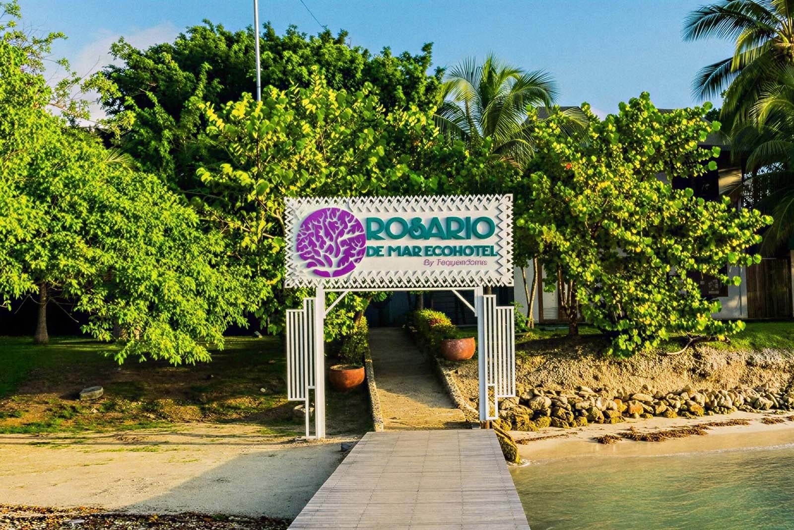 Hotel Rosario de Mar by Tequendama: muelle, vegetación exuberante y letrero icónico. ¡Tu escapada caribeña en Islas del Rosario te espera!