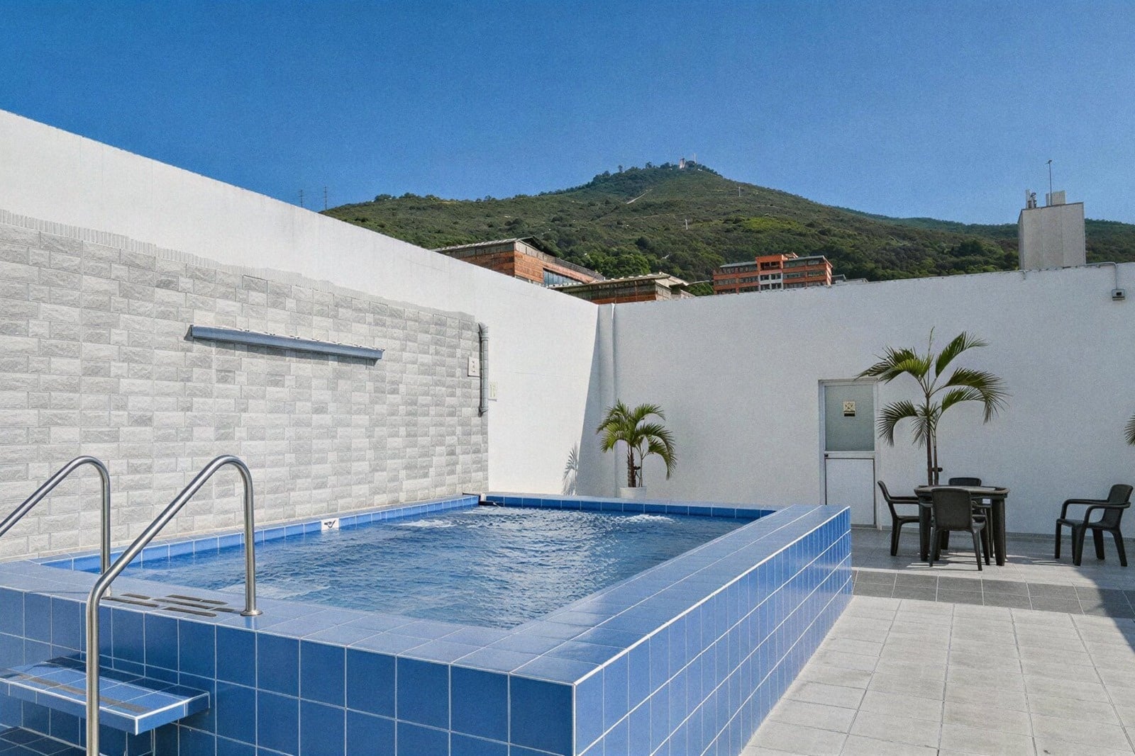 Rooftop pool at Tama Hotel Granada Real, offering stunning mountain views and relaxation.