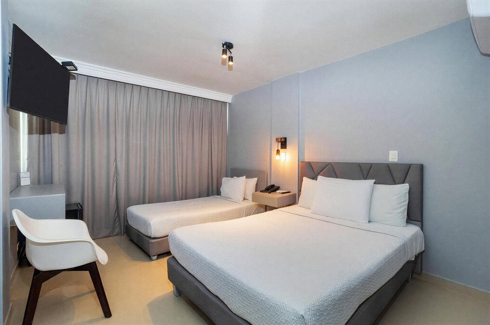 Habitación con dos camas y TV en Gio Hotel Tama Cartagena, Bocagrande.