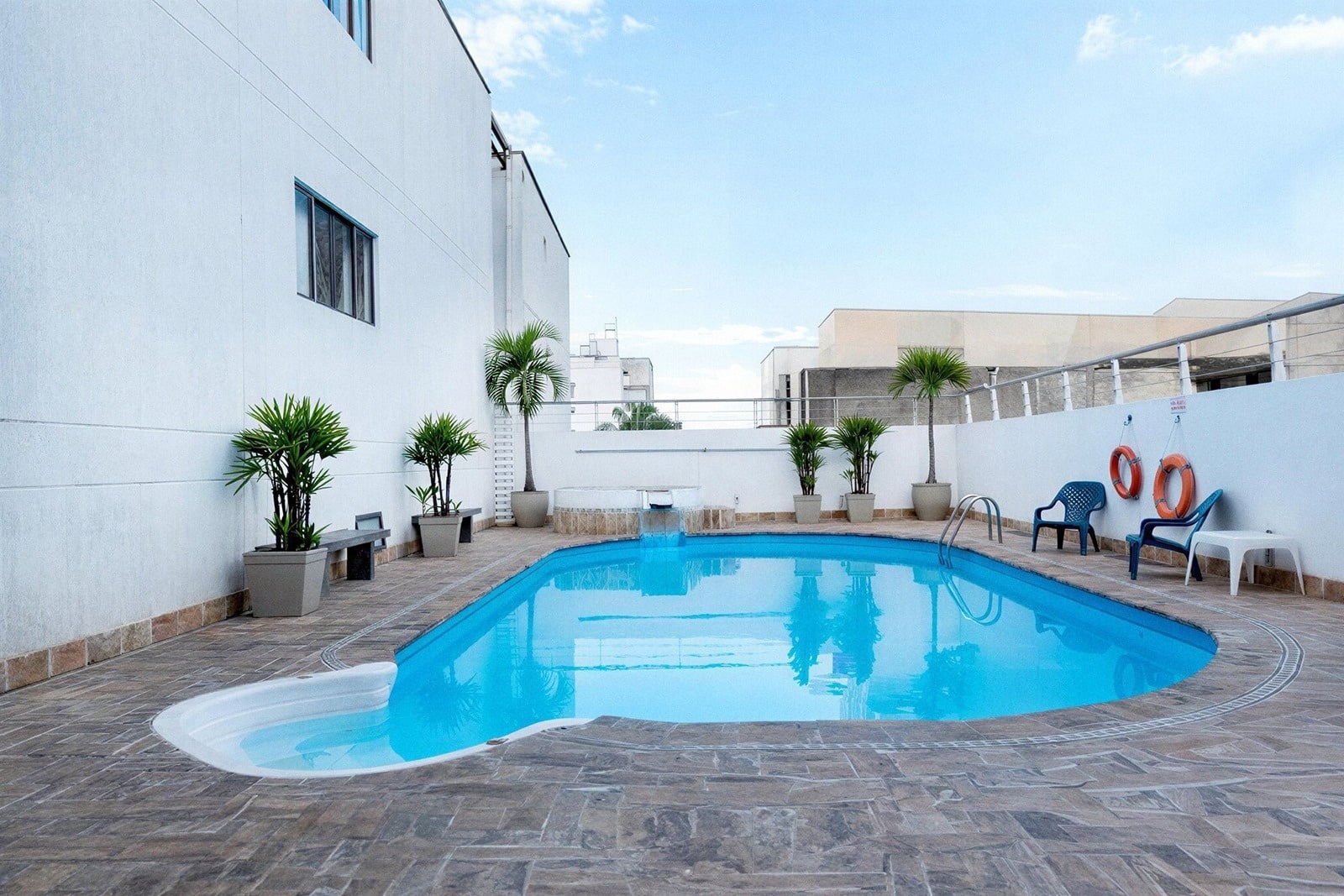 Tequendama: Corporativa piscina refrescante con sillas y palmeras.