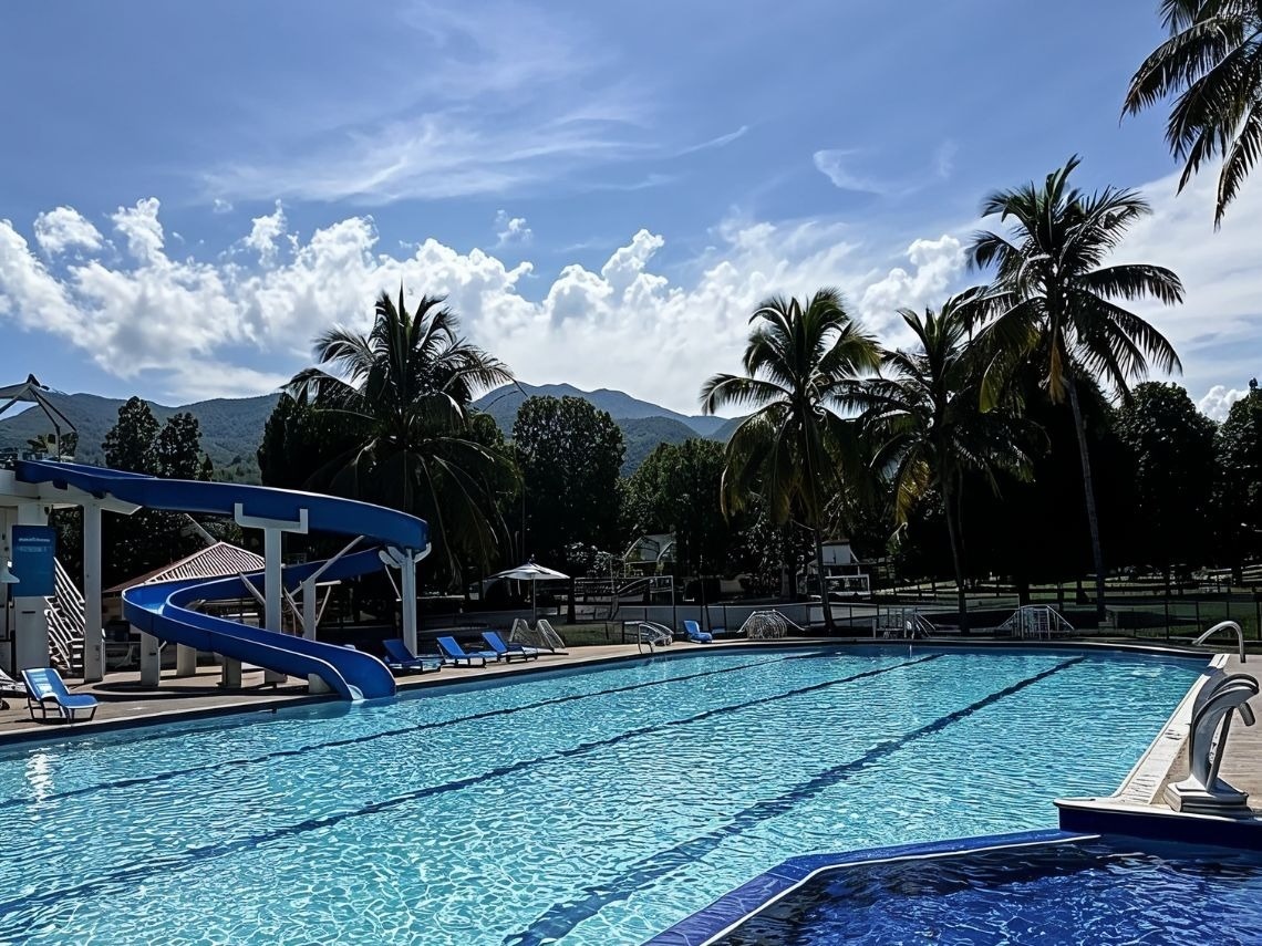 Piscina con tobogán y palmeras en Tequendama Hoteles, tu opción en Cundinamarca.