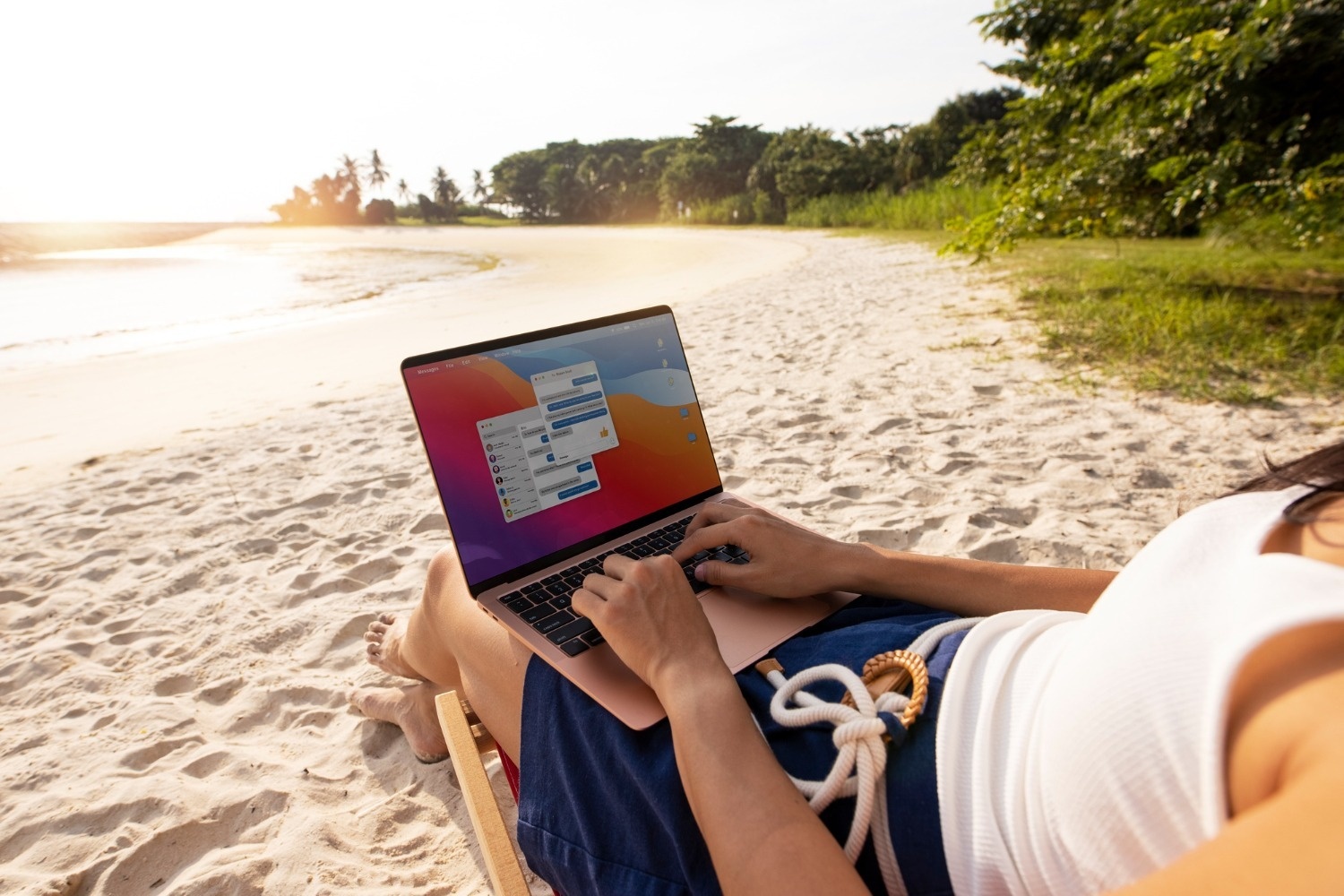 Mujer trabajando en laptop en la playa, Tequendama Corporativa ideal.
