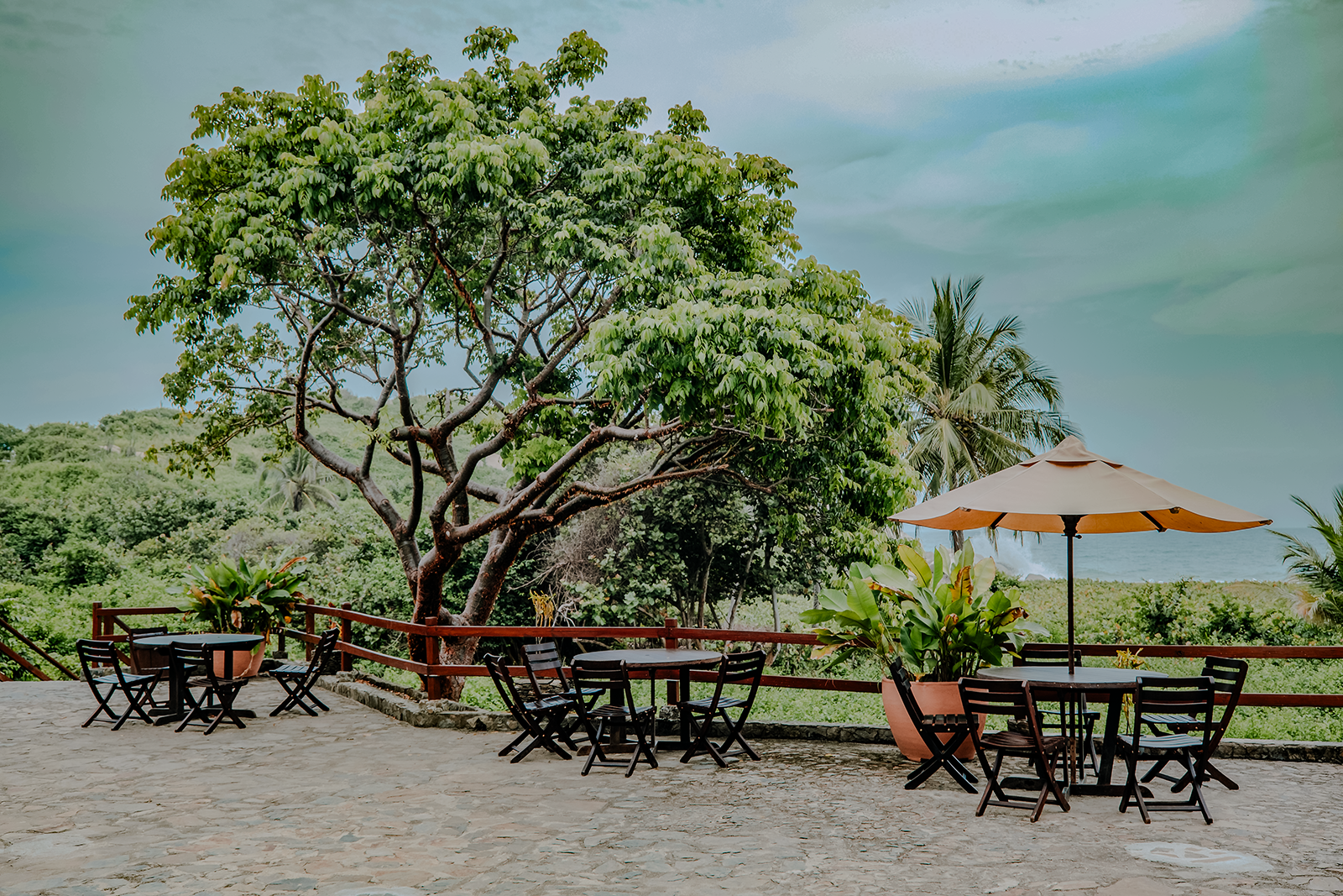 Outdoor seating with umbrella, dining tables, and chairs at Ecohabs Tequendama, near Tayrona Park.