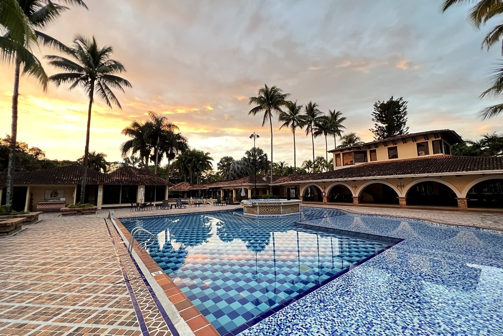 Piscina de Tequendama: Corporativa al atardecer, rodeada de palmeras y edificios.