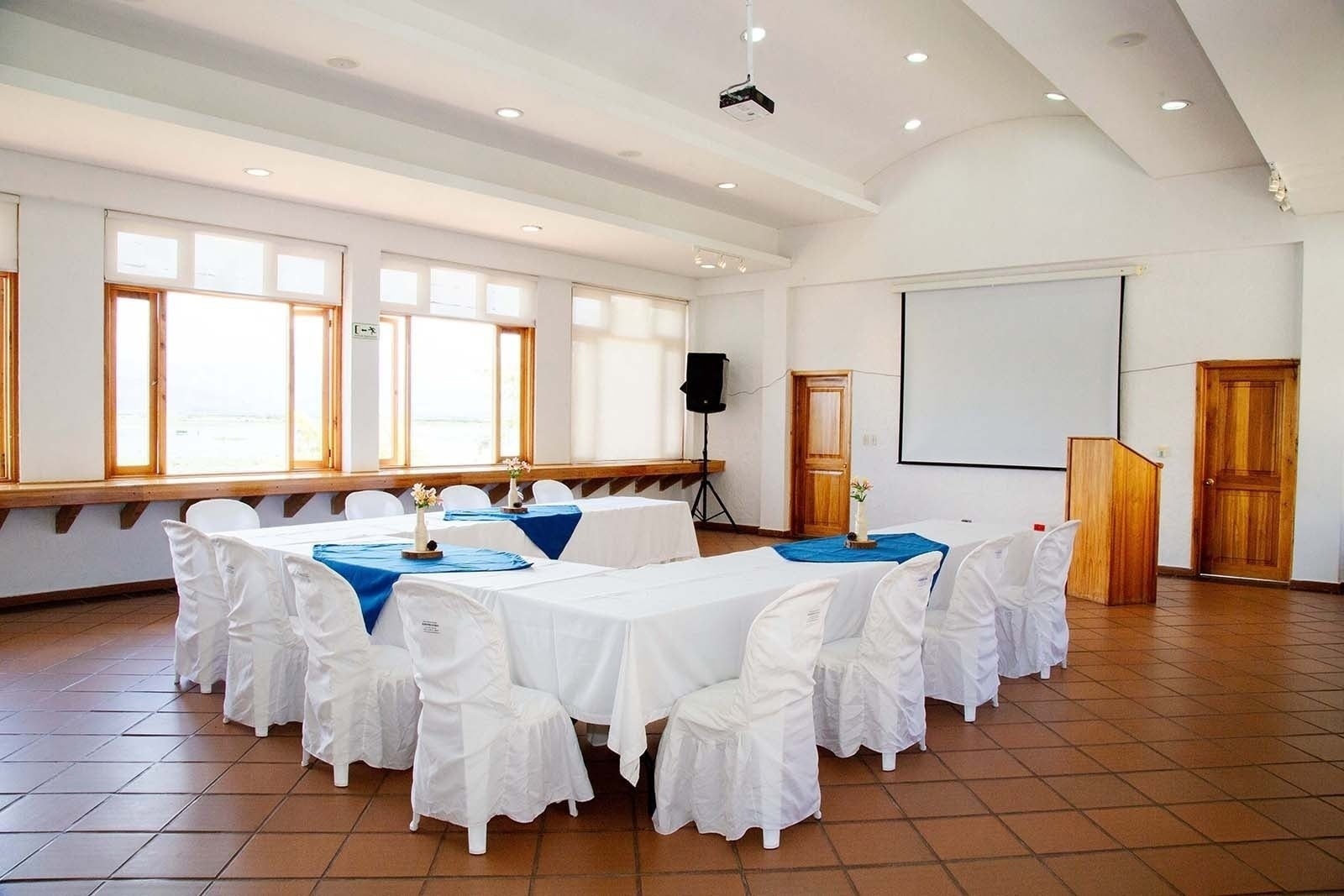 Salón Tequendama: Corporativa, mesas listas para evento con sillas blancas.