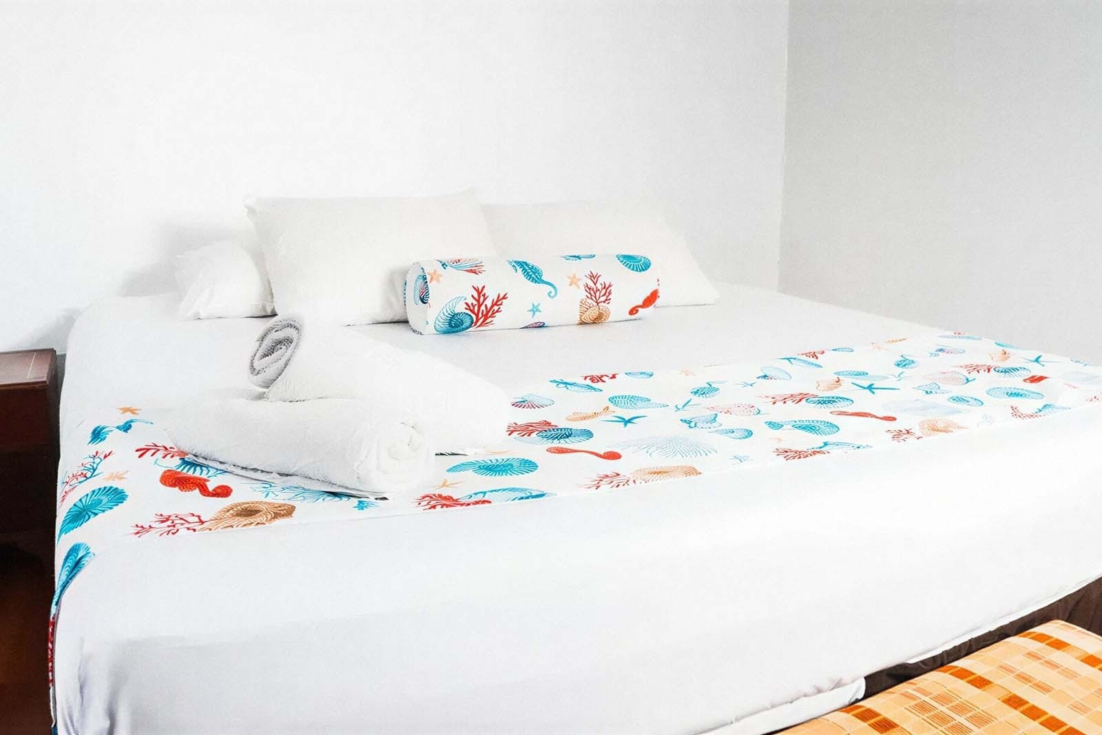 Hotel Rosario de Mar by Tequendama: White bed with nautical-themed runner, pillows, and rolled towels.