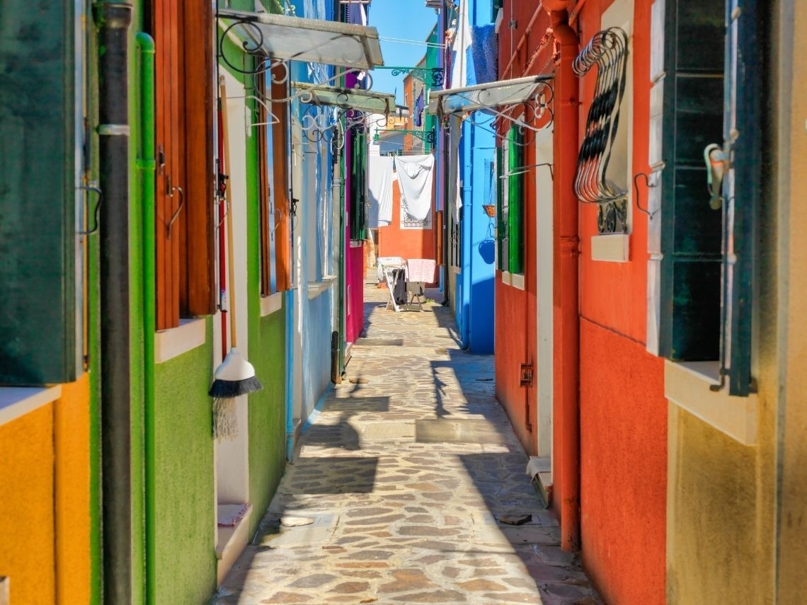 Calle colorida con casas vibrantes, ideal para alojarse en Tequendama Hoteles en Cartagena.